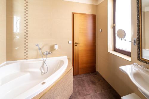 Spa Hotel Vita في تشيسكي بوديوفيتسه: حمام مع حوض استحمام ومغسلة