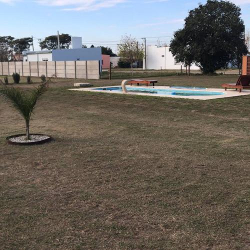 a swimming pool with a small tree in a park at Los Sunchos Casa de Campo in Ataliva
