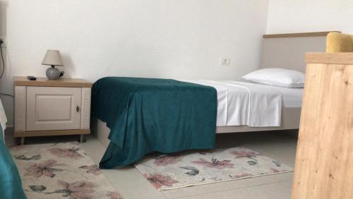 a bedroom with a bed with a green sheet on it at La Foresteria in Galşa