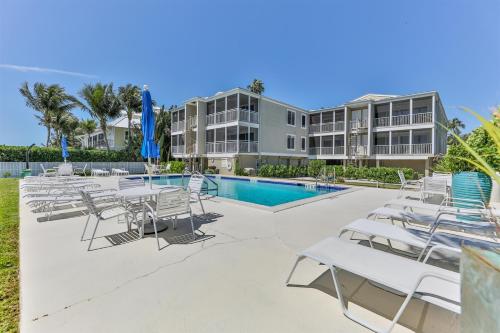 a swimming pool with white chairs and a resort at Captiva Hide A Way 2B in Captiva