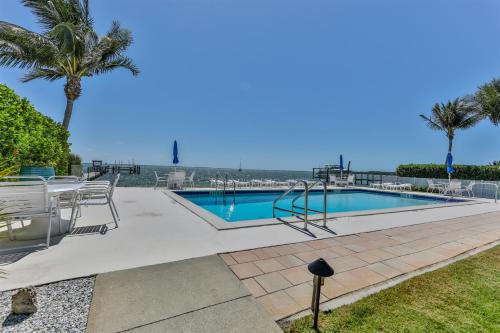 a swimming pool with a table and chairs and palm trees at Captiva Hide A Way 2B in Captiva