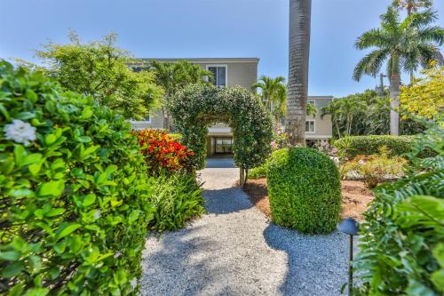a garden with bushes and an arch in front of a building at Captiva Hide A Way 2B in Captiva