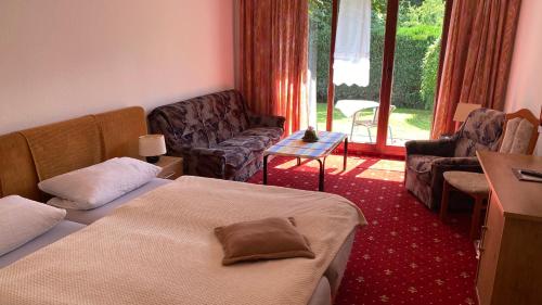 1 dormitorio con 2 camas y sala de estar con sofá en Hotel Pension Brilke Negast, en Steinhagen
