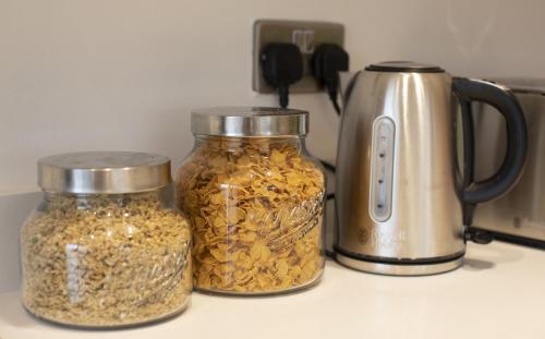 two jars of food on a counter next to a toaster at Charlecote House in Bath