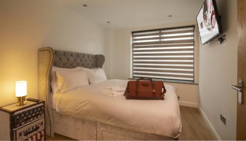 a bedroom with a bed with a bag on it at no 1 Wood Street in Swindon