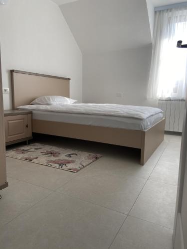 een slaapkamer met een bed, een tapijt en een raam bij La Foresteria in Galşa