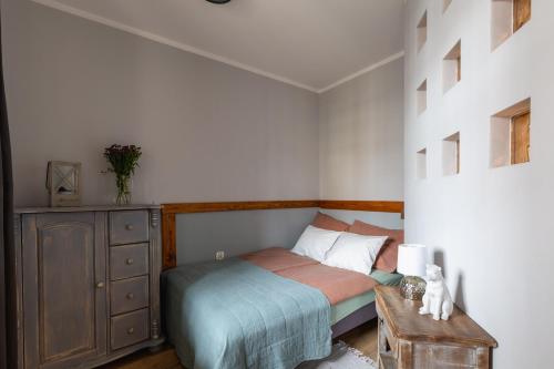 niewielka sypialnia z łóżkiem i komodą w obiekcie Apartament Stare Miasto w Elblągu