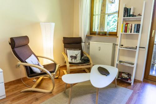 een woonkamer met 2 stoelen en een tafel bij Apartment zum Wohlfühlen mitten im Grünen in Lindberg