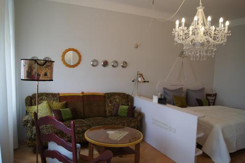 a living room with a couch and a chandelier at Altstadthaus Cityappartements in Graz