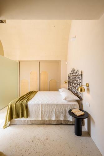 a bedroom with a large bed and a table at Il Giardino Grande - Dimora in Salento in Parabita