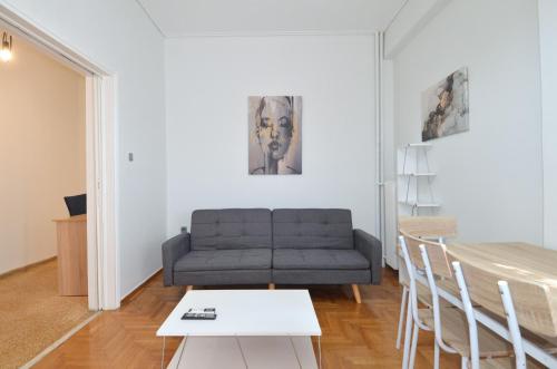 a living room with a couch and a table at A cozy minimal apartment at Koukaki, Dimitrako... in Athens