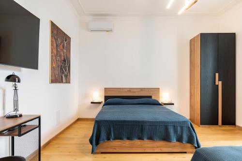 Un dormitorio con una cama y un televisor. en Aurora Rooms, en Catania