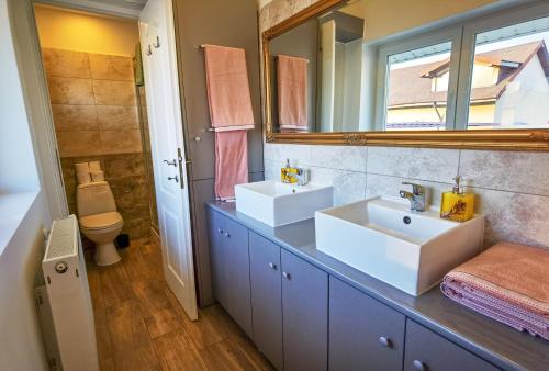 a bathroom with two sinks and a mirror at Apartament 2 camere - Casa Divertis in Buzau