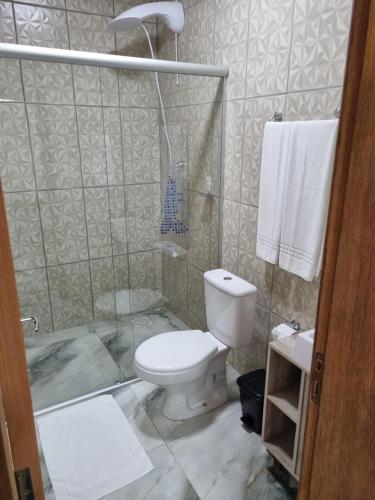 a bathroom with a toilet and a shower with towels at Casa elmar in Canela