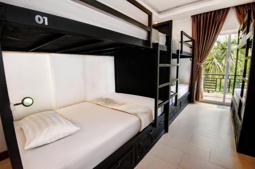 a room with two bunk beds and a window at Mad Monkey Hostel Siem Reap in Siem Reap