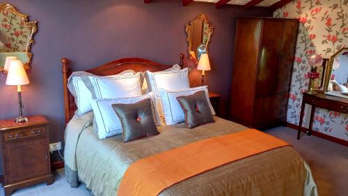 een slaapkamer met een bed met blauwe en witte kussens bij Havenwood in Ayr
