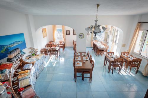 a restaurant with tables and chairs in a room at Hotel Casa Adolfo Ischia in Ischia