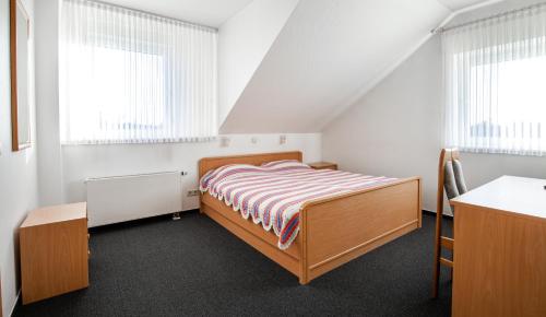 a bedroom with a bed and two windows at Hotel Schwung in Bocholt