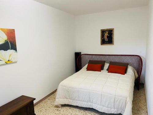 - une chambre avec un lit blanc et 2 oreillers rouges dans l'établissement A'MA CASA, à Modica