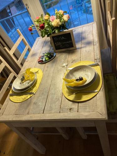 a wooden table with yellow napkins and plates on it at Ferienwohnung Burg Murten in Murten