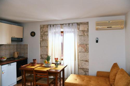 a living room with a table and a kitchen at Freya's Apartments Medulin in Medulin