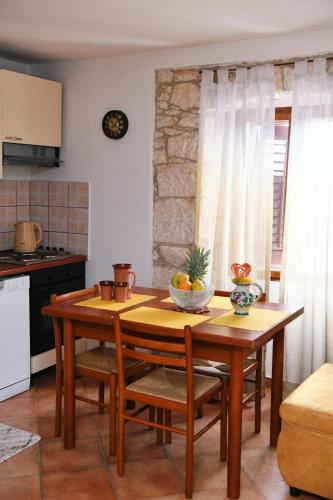 a kitchen with a table with a bowl of fruit on it at Freya's Apartments Medulin in Medulin