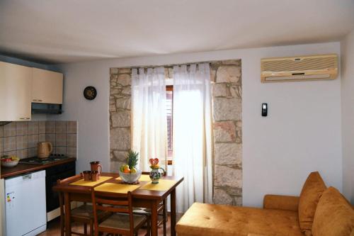 a living room with a table and a kitchen at Freya's Apartments Medulin in Medulin