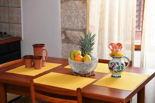 a wooden table with a bowl of fruit on it at Freya's Apartments Medulin in Medulin