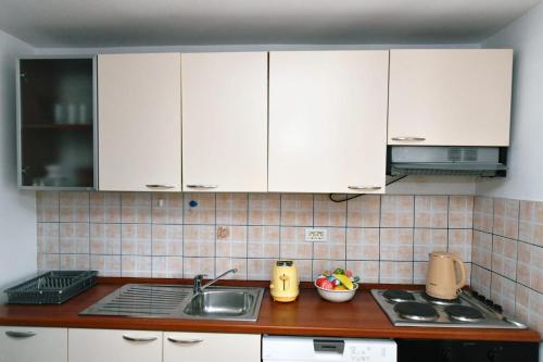a kitchen with white cabinets and a sink at Freya's Apartments Medulin in Medulin