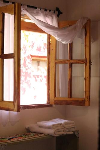 a window in a bathroom with towels on a shelf at Cielito Lindo in Cafayate