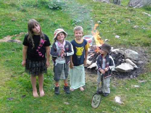 a group of children standing in front of a fire at Untersteinhof in Forstau