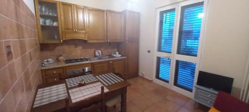 una pequeña cocina con armarios de madera y una mesa. en La Maison à la Mer - Appartamentino a 200 mt dal mare, en Giulianova