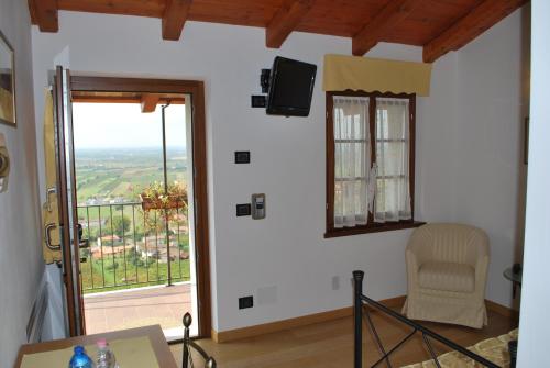 Zimmer mit einem Tisch, einem Stuhl und einem Fenster in der Unterkunft Ciase dal Orcul in Cormòns