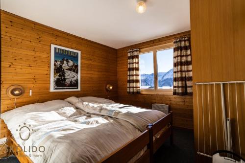 a bedroom with a bed in a room with a window at Chalet Lärchenwinkel, Riederalp Golmenegg in Riederalp
