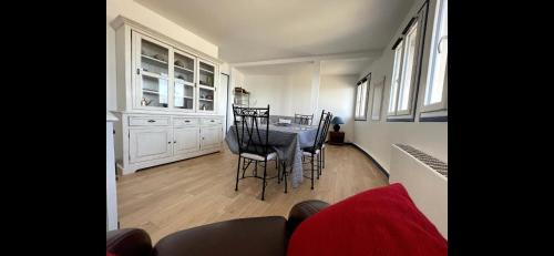 une cuisine avec une table et des chaises dans une pièce dans l'établissement Le Panoramique. Appartement vue mer., à Saint-Valery-en-Caux