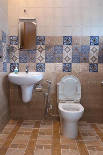 a bathroom with a toilet and a sink at Monsoon Apartments in Kannur