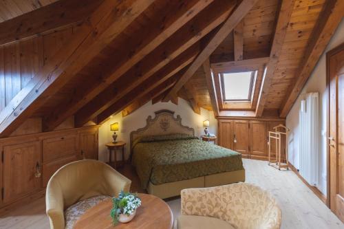 a bedroom with a bed and a table and chairs at Hotel Europa Residence in Asiago
