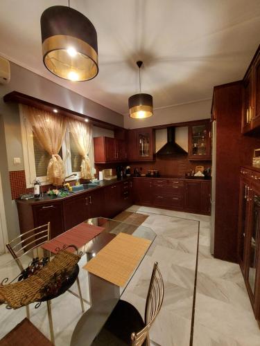 a large kitchen with a table and chairs at La maison de Catherine in Volos