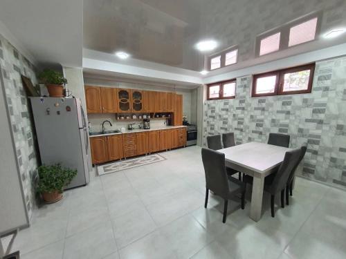 a large kitchen with a table and a refrigerator at Lime Hill Hotel in Kutaisi