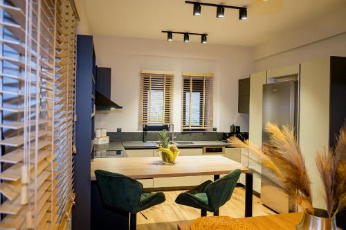 a kitchen with a wooden table and green chairs at Villa de Vino in Ioannina