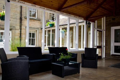 a patio with chairs and tables and windows at Riverdale Hall Hotel & Leisure in Bellingham