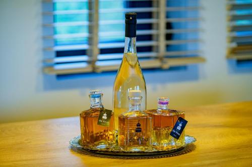 a bottle of alcohol sitting on a glass plate on a table at Villa de Vino in Ioannina