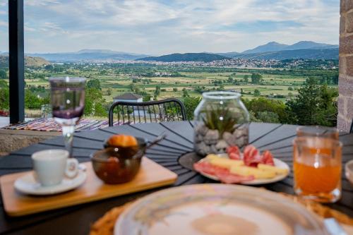 a table with a plate of fruit and wine glasses at Villa de Vino in Ioannina