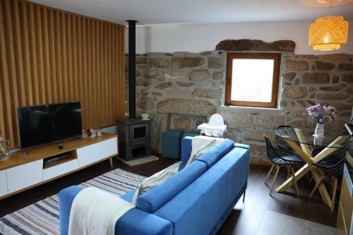 a living room with a blue couch and a tv at Casa do Eirô in Pinheiro