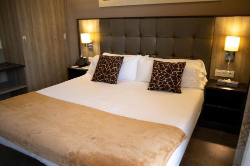 a bedroom with a large white bed with two pillows at Hotel Admiral San Roque in San Roque
