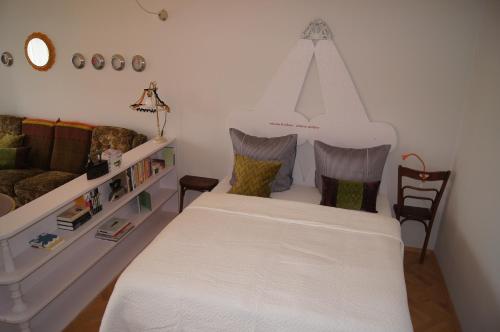 a bedroom with a large white bed and chairs at Altstadthaus Cityappartements in Graz