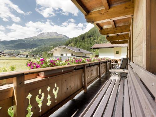 a balcony with a bench and flowers on a building at Apartment Kraxner in Sölden