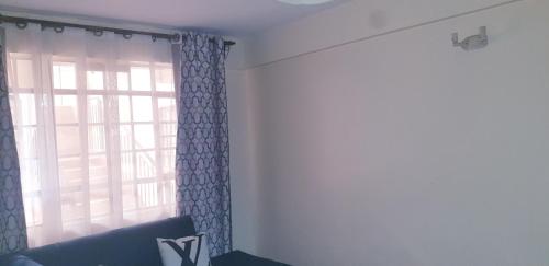 a living room with a window and a couch at Crystal Apartments TRM Drive in Nairobi