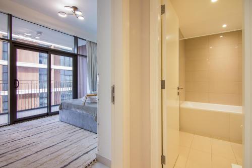 a bathroom with a tub and a bed and a window at Brand new 1 bedroom apartment Dubai Hills 601 in Dubai