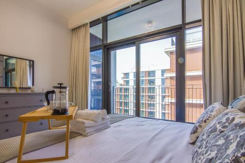a bedroom with a bed and a large window at Brand new 1 bedroom apartment Dubai Hills 601 in Dubai